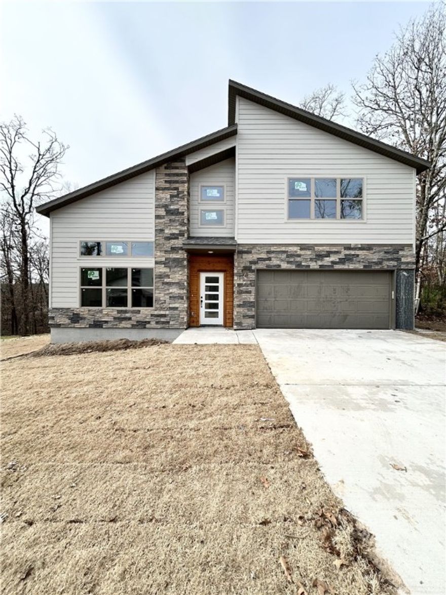 Modern new construction on a .36-acre wooded cul-de-sac lot! 2 bedrooms / 2.5 baths + office. Step into a bright and airy interior featuring tall ceilings and a striking 2-story linear fireplace. The kitchen includes custom cabinets, floating shelves, gas range, and 3 cm quartz countertops. The primary bath features a soaking tub and a walk-in tile shower. Enjoy abundant natural light throughout, and entertain on the spacious deck overlooking the serene landscape. High-end finishes throughout. Located just minutes from the Branchwood Recreation Center and Lake Loch Lomond. As an added bonus, receive $3,500 towards buyer's closing costs when working with the builder’s preferred local lender!
