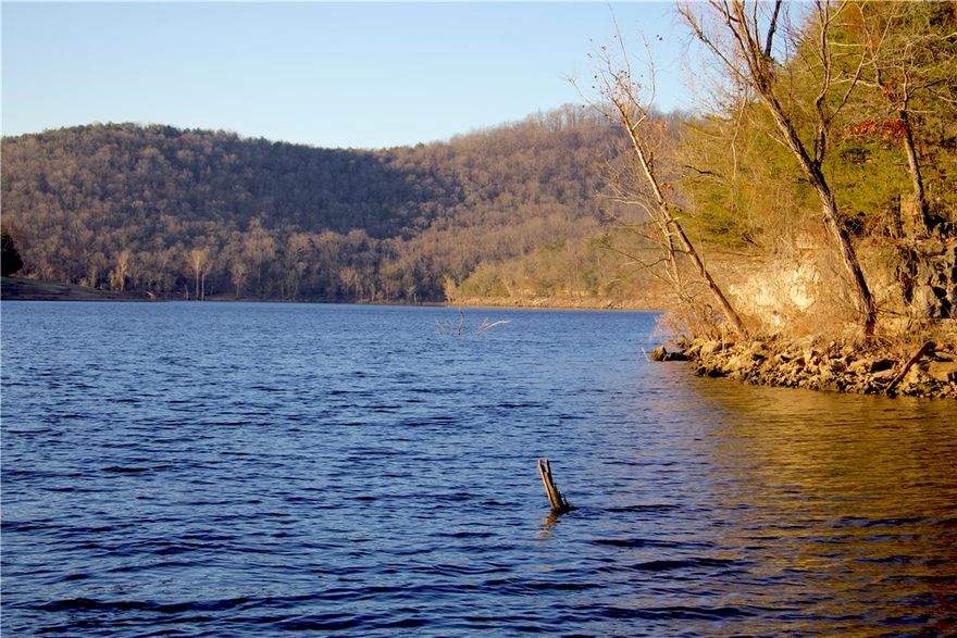 Rare 66± acre tract in Oaks Landing offering privacy, panoramic views, wildlife, and future development potential. Featuring nearly 1,500 ft of Corps of Engineers frontage on Table Rock Lake, this property combines size, affordability, and direct lake proximity. Located at the end of a quiet road, it offers a private, nature-preserve feel with hardwoods, cedar thickets, rock features, and an existing trail system. A stunning hardwood knoll sits approx. 320 ft above the lake, providing an exceptional and private estate-caliber building site with lake views. Enjoy peaceful kayak access or excellent fishing along the shoreline. The land also includes a spring and diverse habitat throughout. As the only remaining subdividable lot in Oaks Landing, it offers strong investment value. Oaks Landing is a secluded 45-lot community with mostly paved roads, peaceful setting, and a resident-owned swim/fish dock, located just 30 minutes from Eureka Springs and less than an hour from Branson and  the NWA metro!