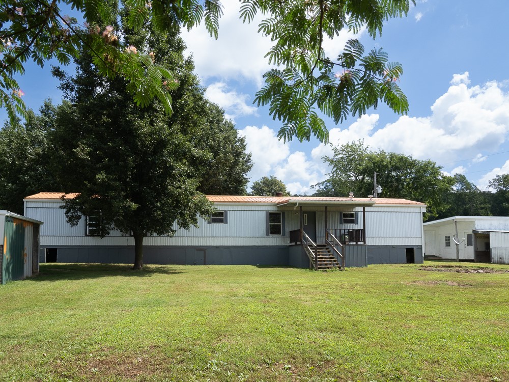 Want to get out of the city and have chickens? Here is .84 acres of perfectly level ground with a small barn that could easily be a chicken coop! An extra storage building to get your stuff out of the weather.
Right off 62, an easy 15 minutes drive to Rogers. Main home has a new heavy duty metal roof. Gateway city water and septic. Owner is a professional roofer, new metal roof was put in recently. Nice shade trees alongside the driveway! Come and see! Sold as is; no repairs.