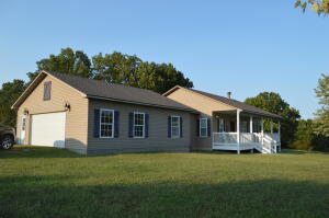 Nice 3 bedroom 2 1/2 bath home sitting on a little over 6 acres just outside of town. This home has an open floor plan & 9 foot ceilings throughout the home. It features an island in the kitchen for entertaining & a wood burning fireplace in the living room for those cool evenings. The 2 car garage is finished and has window heat/air.panels in the barn that make the pens, refrigerator in garage, washer & dryer are not staying with property.