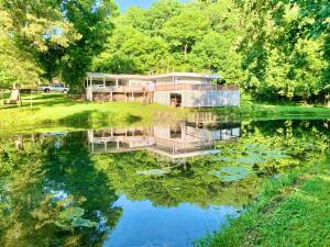 Peaceful countryside home on 15.59 acres, with 2582 Sq ft, 4 bedroom, & 3 full baths. BBQ on the wrap around deck overlooking the pond. Swim in the pond, or fish off the dock. White Oak Creek runs next to the pond. Now connected to Bergman Water and a year round spring provides water to the home if desired. New updates include New Roof, Heat Exchanger and rural water. There is a large garden area. With 4 acres of pasture, there is room for horses or cattle. There are 11+ acres of timber, with a cave. Open concept kitchen/dining area. Wood stove for back up heat. Shop area in basement. 12X24 storage building. Priced below Appraisal!