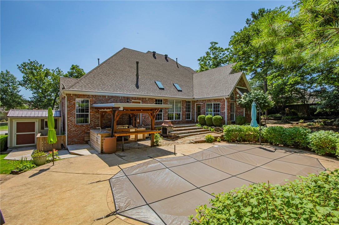 This is a must see home! Located in Bentonville's prestigious Heathrow neighborhood. This home features 4 bedrooms (or 3 bedrooms with a large bonus/media room option), a spacious office with beautiful built in shelves, large formal living space with gas fireplace, soaring ceilings and large windows overlooking a gorgeously landscaped, private backyard. The kitchen has an oversized island, granite countertops, stainless steel appliances and a spacious pantry, open to a large hearth room, 4 season sunroom and eat in area. Hardwood floors throughout the main level. Tons of built-ins and storage both inside and out! You will not want to miss the professionally landscaped backyard with an in-ground, salt water, fiberglass pool with a heater, covered outdoor kitchen/bar area, wood-burning fireplace, fire pit area and 2 storage buildings. Newly installed carpet on the upper level and remodeled bathrooms.