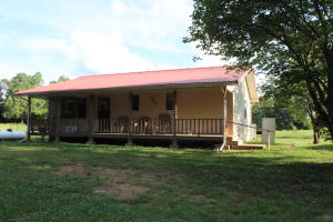 Charming two bedroom home with sun porch, full basement, master suite and metal roof sits just off a county road for easy access. Sit on the covered front porch and enjoy the wildlife while sipping your sweet tea. This home has full basement with many possibilities and a horse barn with attached 15x24 equipment shed. Fenced property will keep your horses and no need to water with a spring fed pond beyond the barn area. If you like quiet country life this one is for you!