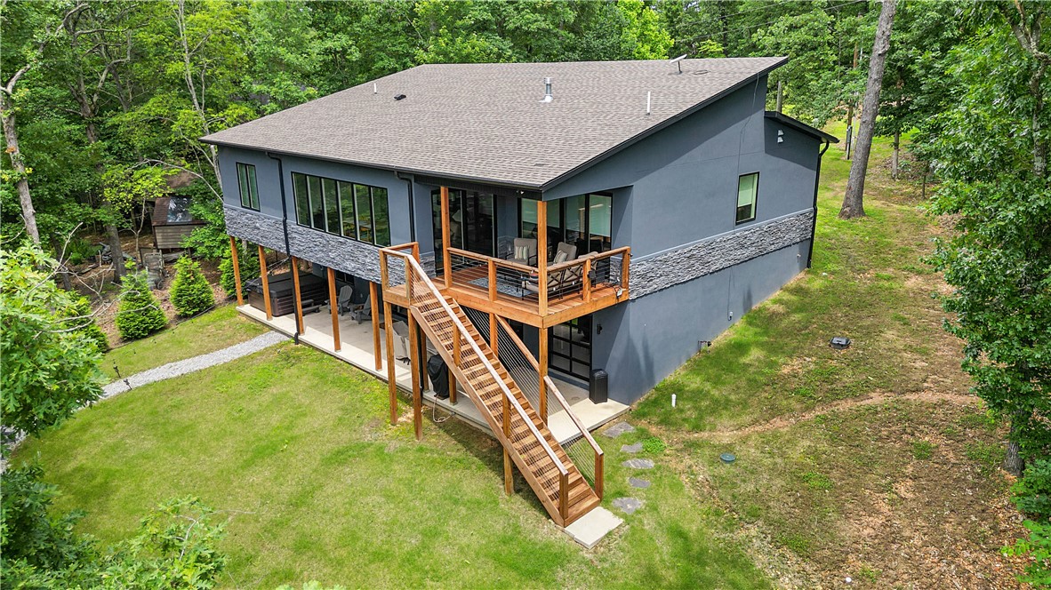 Welcome to the Summit School Trailhouse! This fully furnished, meticulously designed home with quality finishes & custom details, redefines modern living while connecting you with endless outdoor opportunities with direct access to nearby trails & the serene beauty of Lake Ann. Whether this is your private sanctuary, an income producing property, or both, you’ll quickly realize this is more just a home, it’s a lifestyle. The main level has 3 bdrms with a private balcony off the primary suite, a shou sugi ban gas fireplace, monogram appliances, & tons of natural light! Downstairs you'll find a 4th bedroom, full bath, 2nd utility rm, 2nd living rm with wet bar, a deluxe bike shop/game room that's perfect for hobbies & entertaining, a massive covered back porch, and 2 spacious owners closets/additional storage. The hot tub & fire pit are ideal for cozy nights under the stars reflecting on your days adventures or planning tomorrows. Owners willing to transfer current STR with all furniture & housewares. 3 bdrm septic