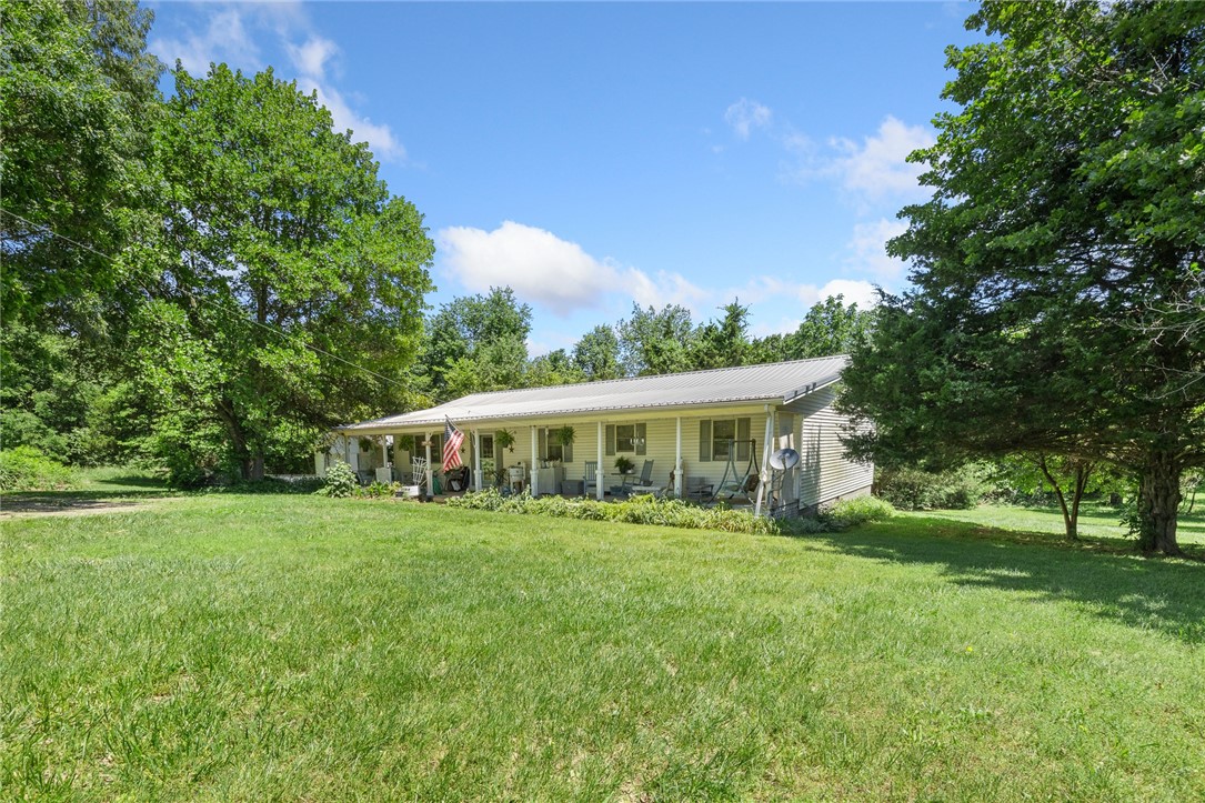 Welcome to your dream home - a charming Modern Farmhouse with 1,960 sq ft of beautifully designed living space, nestled on 2.77 m/l acres of wooded land located ideally between Harrison and Branson. Step inside this thoughtfully crafted 3-bedroom, 2-bathroom home, where comfort meets versatility. You'll love the option for dual primary suites, ideal for multi-generational living or guests. The open floor plan offers a seamless flow between living, dining, and kitchen areas — perfect for everyday living and entertaining. Enjoy peaceful mornings on the picture-perfect covered front porch and cozy evenings in your enclosed sunroom or snuggled up in front of the gas log fireplace. Don’t miss your chance to own this slice of modern country paradise — it’s everything you’ve been looking for, and more!