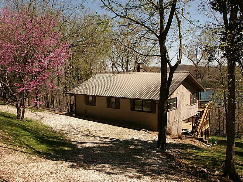 Cozy lake cottage with great view and private feel! Located in Mundell Heights subdivision but is the only house on this street. Great views from home's many windows and decks. Amenities: French doors from the master bedroom, a gas log fireplace, eat-in,kitchen, storage shed, large lower deck for entertaining, hanging canoe over Dutch door entry, 2 lots included, adjacent lots for sale. Paved roads get you very close to this house and a community well supplies the water. The furniture is included!