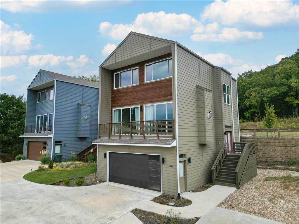 This immaculate home offers a mix of contemporary and modern living. The 3 level spilt floor plan with unmatched views presents 4 bedrooms, 3.5 bathrooms. ITs location offers convenient access to the University of Arkansas, Downtown Fayetteville, Dickson St. and I-49. While on the second-level (main level), enjoy views through floor to ceiling doors that also give you access to the balcony. This level houses an outstanding kitchen with large breakfast bar, dining and living room. In addition, this level also offers a spacious laundry room, multi-use and access to the back patio. On the top level you can find the frst master suite with oversized windows and walk-in closet, in addition to two other bedrooms. On the lowest level of this home, you can find a second master suite with access to a second patio. Come see this gorgeous home today!