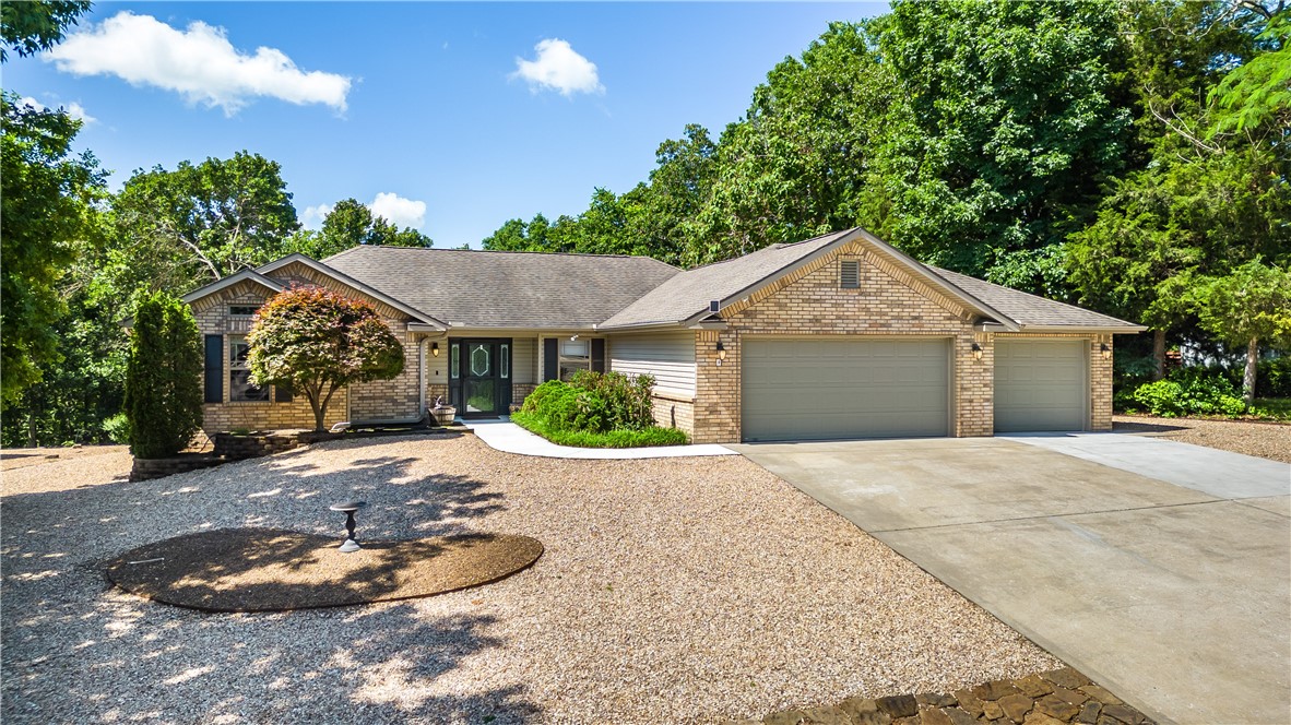 Welcome to 4 Marykirk Lane in Bella Vista! This split floorplan home has been meticulously maintained and has a 3-car garage (rare at this price point!). Lake Loch Lomond is just at the end of the cul-de-sac and can be seen from the back patio. Natural light just pours into the sunroom with a backdoor leading out to the patio. The oversized patio overlooks the backyard with plenty of space for relaxing or entertaining. The eat-in kitchen features granite countertops, stainless steel appliances, pantry & utility closet. The primary suite includes a dual vanity, jetted tub, walk-in shower and walk-in closet. Wood appearance tile floors flow throughout the main living space. Gas fireplace in living room. Laundry room includes a utility sink and is located between the kitchen and garage. The oversized yards are rock landscaped and low maintenance.