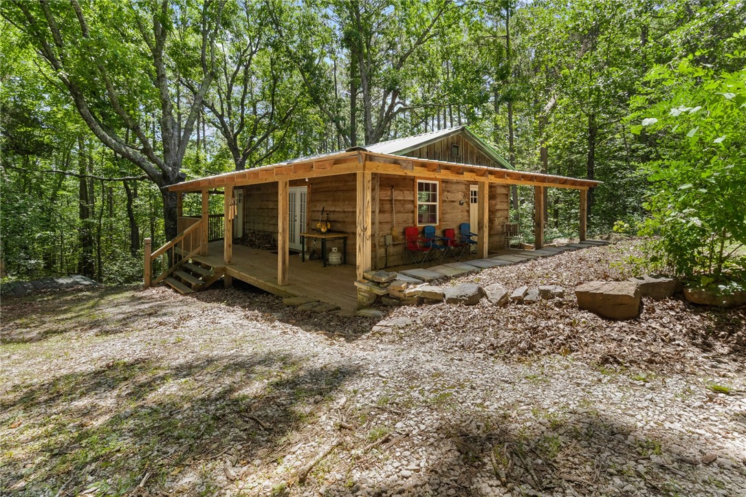 Looking for Seclusion, Privacy, and Peaceful Living? This could be your place. 3 homes in one with 29 acres and 2 ponds. First cabin is a one-bedroom, one-bath, and a living room. Next to this is the Earth Home that features 3 bedrooms, 1 bath, 2 living rooms with 2 fireplaces, and several outbuildings. The second cabin has a separate driveway but is within walking distance to the first cabin and the Earth home. This cabin has a wrap-around porch, 2 bedrooms, 1.5 bathrooms, a living room, and a kitchen. 2 cabins come fully furnished. The large pond is stocked with lots of fish, 2nd pond is spring-fed. SOLD AS IS!