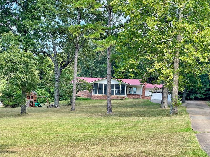 This 4 acre property presents a rare opportunity to own more than a small lot within the city limits, boasting a picturesque park-like setting and effortless access to local amenities. The 2-bedroom, 2-bathroom residence offers 1680 sq ft of living space, office/flex room off the kitchen, further enhanced by a spacious 288 sq ft screened porch/sunroom in the front entrance of the home. A separate 10x16 building provides versatility for use as an art studio, office, or guest room.Ample storage space is available in the garage. This home showcases character and charm, set amidst a serene 4-acre backdrop within the city limits.With convenient access to Hwy 412, discover NW AR's comprehensive trail network featuring biking, hiking, and mountain biking trails.Enjoy a variety of outdoor pursuits, including camping, fishing, and water sports, with easy access to Beaver Lake, War Eagle Creek, and the Buffalo National River. Utility availability is the responsibility of the buyer or buyers agent.