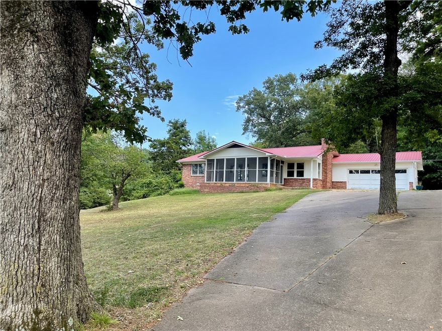 This 4 acre property presents a rare opportunity to own more than a small lot within the city limits, boasting a picturesque park-like setting and effortless access to local amenities. The 2-bedroom, 2-bathroom residence offers 1680 sq ft of living space, office/flex room off the kitchen, further enhanced by a spacious 288 sq ft screened porch/sunroom in the front entrance of the home. A separate 10x16 building provides versatility for use as an art studio, office, or guest room.Ample storage space is available in the garage. This home showcases character and charm, set amidst a serene 4-acre backdrop within the city limits.With convenient access to Hwy 412, discover NW AR's comprehensive trail network featuring biking, hiking, and mountain biking trails.Enjoy a variety of outdoor pursuits, including camping, fishing, and water sports, with easy access to Beaver Lake, War Eagle Creek, and the Buffalo National River. Utility availability is the responsibility of the buyer or buyers agent.