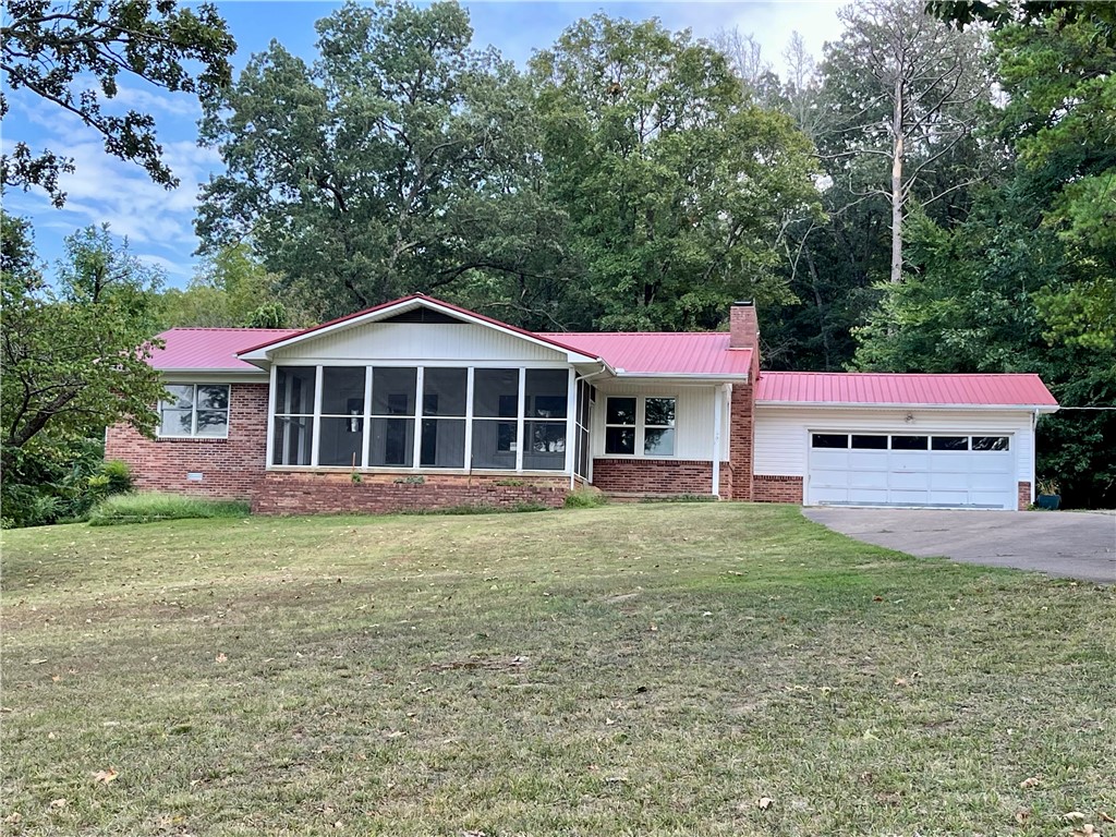 This 4 acre property presents a rare opportunity to own more than a small lot within the city limits, boasting a picturesque park-like setting and effortless access to local amenities. The 2-bedroom, 2-bathroom residence offers 1680 sq ft of living space, office/flex room off the kitchen, further enhanced by a spacious 288 sq ft screened porch/sunroom in the front entrance of the home. A separate 10x16 building provides versatility for use as an art studio, office, or guest room.Ample storage space is available in the garage. This home showcases character and charm, set amidst a serene 4-acre backdrop within the city limits.With convenient access to Hwy 412, discover NW AR's comprehensive trail network featuring biking, hiking, and mountain biking trails.Enjoy a variety of outdoor pursuits, including camping, fishing, and water sports, with easy access to Beaver Lake, War Eagle Creek, and the Buffalo National River.