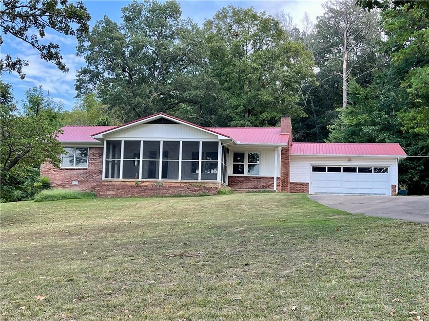 This 4 acre property presents a rare opportunity to own more than a small lot within the city limits, boasting a picturesque park-like setting and effortless access to local amenities. The 2-bedroom, 2-bathroom residence offers 1680 sq ft of living space, office/flex room off the kitchen, further enhanced by a spacious 288 sq ft screened porch/sunroom in the front entrance of the home. A separate 10x16 building provides versatility for use as an art studio, office, or guest room.Ample storage space is available in the garage. This home showcases character and charm, set amidst a serene 4-acre backdrop within the city limits.With convenient access to Hwy 412, discover NW AR's comprehensive trail network featuring biking, hiking, and mountain biking trails.Enjoy a variety of outdoor pursuits, including camping, fishing, and water sports, with easy access to Beaver Lake, War Eagle Creek, and the Buffalo National River. Utility availability is the responsibility of the buyer or buyers agent.