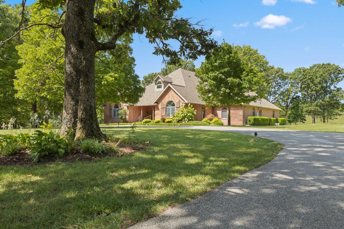 Discover an exceptional residence set on over 9 pristine acres, featuring an array of luxurious amenities. This stunning property includes a main home with 4 bdrms & 4.5 bathrooms, entire upstairs bonus room can be converted into more bdrms & includes a large guest house. The main living areas boast gas fireplaces, elegant hardwood floors, & soaring 12' ceilings, while the dining room accommodates a massive table for entertaining. The gourmet kitchen is outfitted with granite countertops, all appliances, pantry & a Butler's Pantry, ensuring a seamless cooking experience. There is a nice sunroom & a master suite featuring french doors to the covered patio, dual walk-in closets & an expansive bathroom. The large safe room can be accessed from 2 floors. Main home has 3 large garages & the detached guest house has 3 garages with one large enough for an oversized RV. Home has city water and a separate well. If you can dream it in a home, this one has it!! (See attached document for more details. Roof is 4 yrs old)