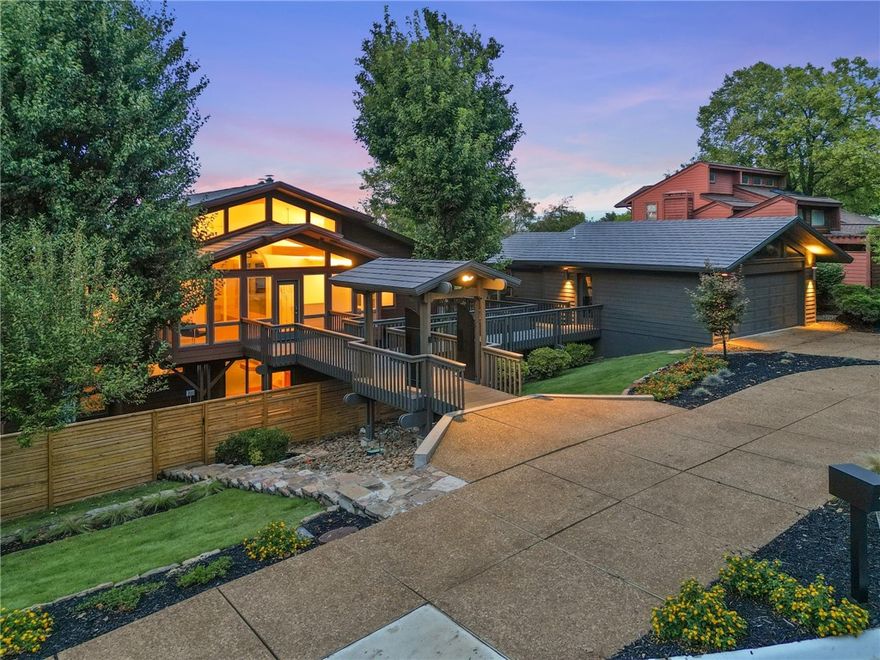 Fabulous Remodel! Walk to Razorback Stadium & embrace the ultimate game-day experience!  Tailgate at this fabulous 'Party House"! Enjoy one-of-a-kind elegant contemporary estate with full house generator.  Exercise in your own private indoor lap pool attached to the oversized 2 car oversized garage or stroll out back gate to community pool & tennis court.  Enter thru gate & take walkway in atrium/sunroom & endless white oak floors. This level boasts a gorgeous living area, barrel ceiling, & fireplace trimmed with stunning black quartzite. The kitchen's fresh new look has a breakfast bar, all new stainless appliances, bar area with ice machine, huge dining area & tons of cabinets. Remodeled primary ensuite is also on the main level along with second bedroom, guest bath, laundry area, & oversized covered porch with great views of Fayetteville. The upstairs & down can be totally separate units! Downstairs has another full kitchen, laundry room, living room with fireplace, 2 bedrooms, 2 baths, & a large enclosed porch.