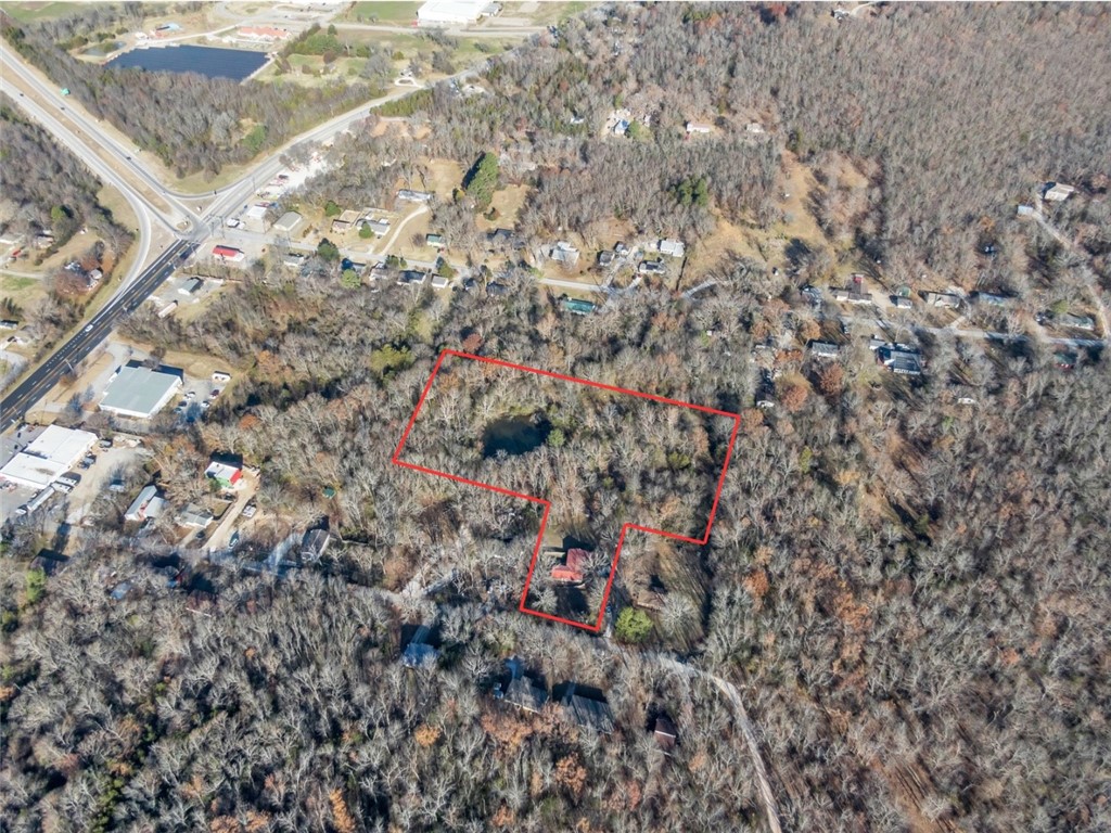 Incredible location in South Fayetteville with scenic 5.94 acres! The flat backyard features a large pond with live fish and walking trails! No through traffic on this dead-end street makes it a perfect getaway while being minutes to I-49 access and downtown Fayetteville. Covered deck offers privacy and fully fenced side yard is pet friendly. Property features a 3 bedroom, 2 bathroom house with 1,728 SF and a bonus room that can be used as a fourth bedroom. Partially remodeled with new flooring and new covered decking. Investors: The 5.32 acre parcel is considered a tandem lot zoned RSF-4. House is in Greenland school district but land parcel appears to be in Fayetteville school district. Buyer to confirm.