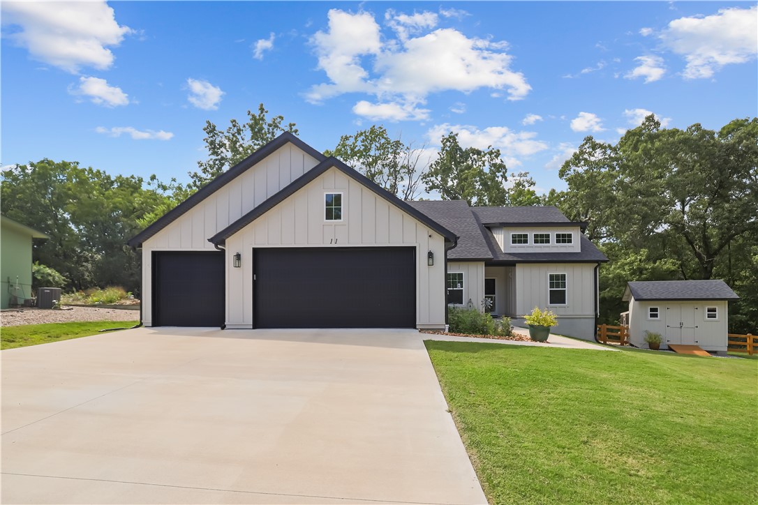 Discover this stunning 2023 craftsman-style home at the end of a quiet cul-de-sac, backing to serene woods for privacy. Offering 3 bedrooms, 2 full bathrooms, and a dedicated office, this home blends style and function. The spacious living room is filled with natural light from large windows overlooking the gently sloping, fenced backyard and features a cozy fireplace with built-in shelves and storage.
The kitchen showcases quartz countertops, a cleverly concealed pantry, and practically new matching stainless steel appliances plus a fridge that conveys with an acceptable offer. The luxurious primary suite features a seamless-glass walk-in shower, a deep soaking tub, and a large walk-in closet.
Outside, enjoy an extended partially covered deck, a matching storage shed, and a three-car garage with 8-foot doors and workshop space. Located within Bella Vista city limits, this property offers easy access to Tunnel Vision Trail and full POA amenities including golf, tennis, recreation facilities, and lakes.