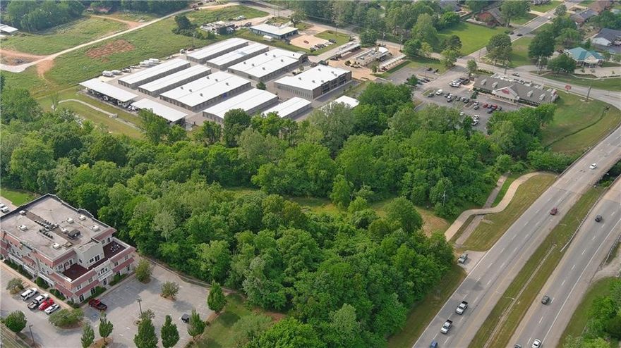 Serene tract of land in a prime, high-traffic location just off US-71B! Property borders portions of the Razorback Greenway bike trail and Clear Creek, offering great visibility and accessibility. Conveniently located near the Northwest Arkansas Mall, Lake Fayetteville, and Springdale Country Club. Endless potential for development or lease opportunities such as food trucks, a snow cone stand, or produce market. Approximately 1.25 acres adjacent to the creek, located in the floodplain. Sewer access may be available uphill toward the mall; will not perc for septic.