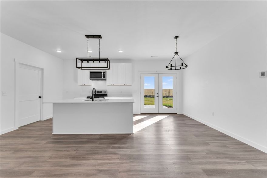 Brand new construction in a peaceful country setting with beautiful backyard views! This thoughtfully designed home offers modern finishes, quality craftsmanship, and an open-concept layout perfect for today’s lifestyle. The kitchen is the heart of the home, featuring quartz countertops, a spacious island with double sink, stainless steel appliances, crisp white cabinetry, and stylish black hardware and lighting for a clean, contemporary look. The open living and dining areas are filled with natural light and showcase durable wood-look flooring throughout. Enjoy the convenience of a dedicated laundry/mudroom space with built-in cabinetry and extra countertop storage. Large windows frame the scenic views, creating a bright and inviting atmosphere inside while allowing you to enjoy the beauty of the countryside. Step outside and take in the peaceful surroundings and wide-open backyard views—perfect for relaxing evenings, entertaining, or simply enjoying country living. Move-in ready and built to impress!