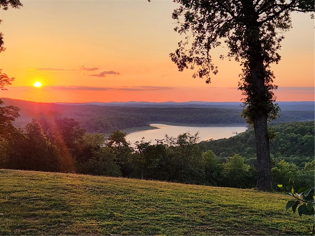 Serene Retreat in the Beautiful Ozarks! Located on 31 ac, this retreat offers a blend of comfort & charm. Breathtaking views of the mountains & Bull Shoals Lake, this home boasts 5 BR and 3 BA, providing ample space for family & guests. Oversized family room is perfect spot for cozy evenings or lively celebrations.
A workshop with a drive-through garage and 2 carports large enough to accommodate your RV, boat, and additional vehicles. Enjoy the 3 covered porches, perfect for barbecues or outdoor parties. Home has a designated safe room, Generac whole house generator & 500-gallon propane tank for reliable power & energy efficiency. The full finished walk-out basement is plumbed for an add'll kitchen, mother-in-law suite or entertainment zone. The property has abundant wildlife & is just 3 miles from the Peel Ferry & 125 Marina, If you're seeking a peaceful escape, this property offers it all. Come and experience the serenity and splendor of the Ozarks in your very own retreat.