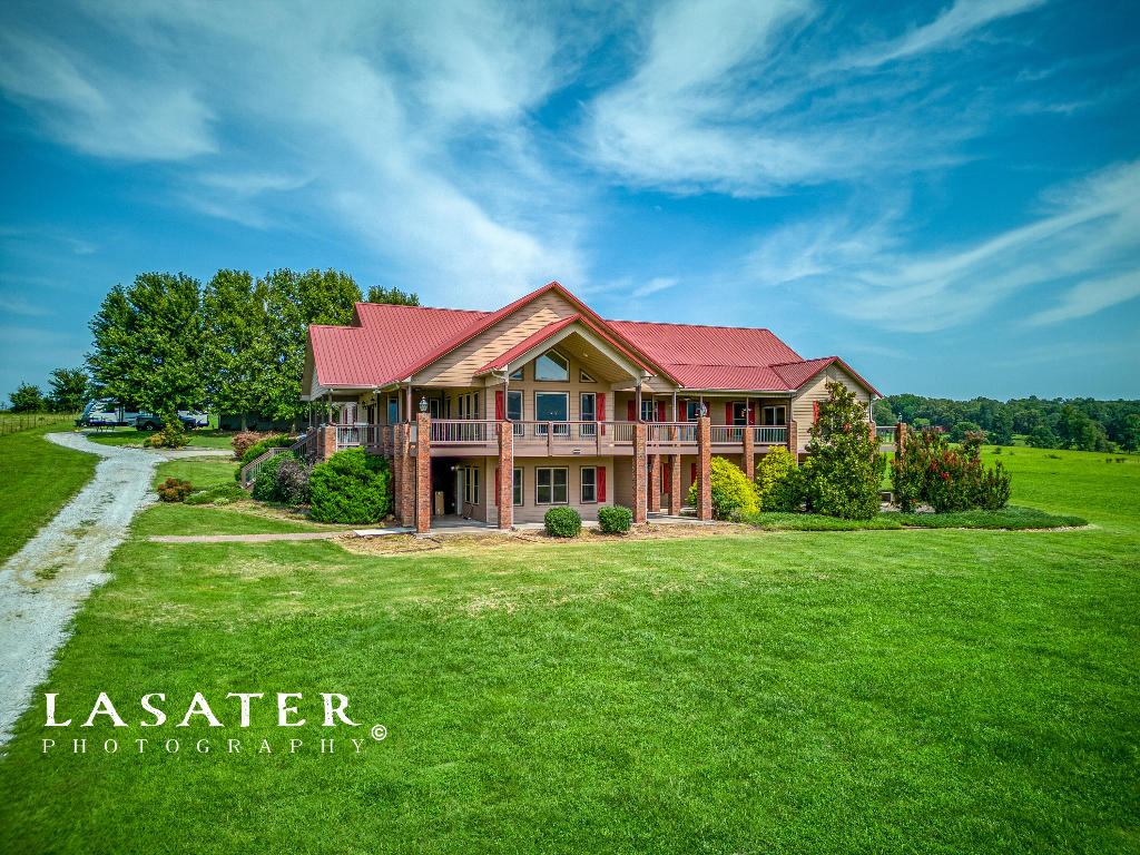 Discover the breathtaking panoramic views of Gaither Mountain from this magnificent home nestled on 13 acres, with over 8200+ sq ft of living space. This 5 bed 3 bath home features two fully -equipped kitchens- one on the main level and another in the basement. The primary suite is a true retreat, offering an abundance of space and a spa-like experience with a jacuzzi tub and a huge shower. Vaulted ceilings in the living room and hardwood floors throughout the main living area elevate the sense of openness. Enjoy wrap-around porches on both the main and basement levels, inviting you to soak in the stunning views. The detached 30 x 40 shop is complete with full living quarters and a workshop. With the Buffalo National River just 10 miles away, this home offers seclusion and convenience.