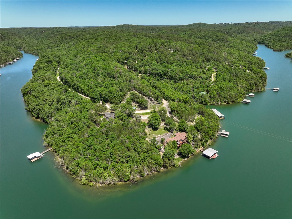 Exceptional one owner Lakefront residence with over 340' frontage on pristine Beaver Lake. A wide covered front porch welcomes you to this charming 3 bedroom, 3 full bath dream home featuring 2 levels of comfortable living space making it the ideal luxury residence/family retreat. Abundant living spaces including main floor family room with stone fireplace, breathtaking sun room with cathedral ceiling, cozy den, & comfy breezeway. Culinary enthusiasts will enjoy the stunning kitchen that boasts a copper sink, center island, breakfast room, and a window overlooking upper deck & lake. Expansive upper & lower decks offer breathtaking 180' views of this slice of paradise. Remodeled primary suite with spa bath offering whirlpool tub, seperate shower, & walk-in closet. Walkout lower level offers huge 3rd brm, full bath, family room/game area with amazing wet bar. The semi-private dock is complete with 2 slips & fun slide, perfect for boating enthusiasts, swimming, or relaxing overlooking the shimmering waters.
