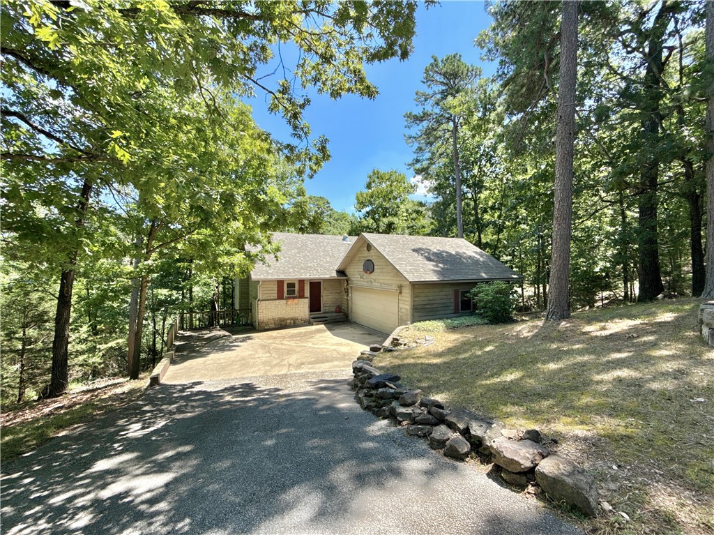 Tucked at the end of a quiet cul-de-sac, this 1,733sqft 3bed/2bath home offers the best of both worlds, close to the heart of Eureka Springs, yet surrounded by peaceful woods for added privacy. The open-concept main floor features a full bathroom, spacious living room with vaulted ceilings, a wood-burning fireplace & a pull-down projector screen. It flows seamlessly into the dining area & eat-in kitchen, with french doors off the dining area opening to a large upper deck, perfect for enjoying quiet mornings. Wooded views from nearly every window give the home a retreat-like feel, you might never want to leave, except to stroll through historic downtown just minutes away. Downstairs, you’ll find the 3 bedrooms & a full bath. The primary bedroom includes 2 closets & its own private deck, which wraps around to a large patio with a hot tub. Want peace & quiet without giving up proximity to shops, restaurants & attractions? This home checks all the boxes & with a little love it could be your perfect hideaway or rental.