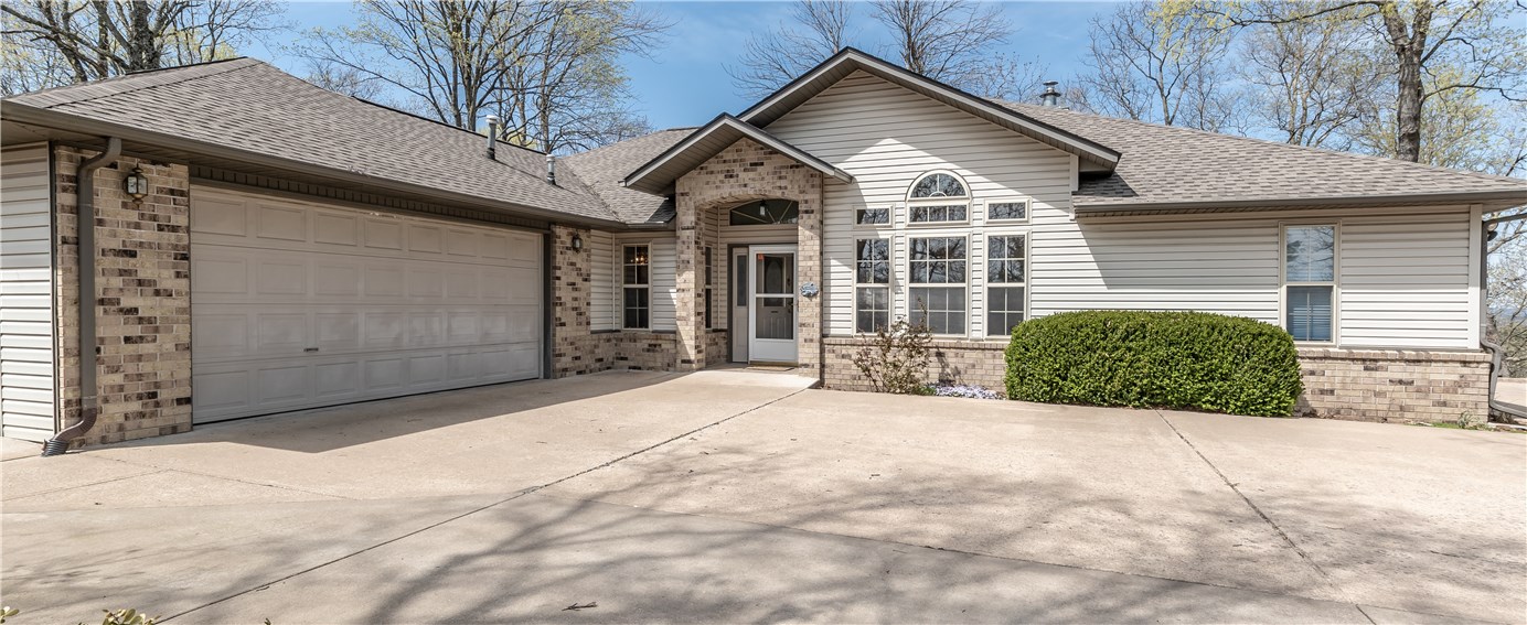 Mountaintop Retreat with Stunning Views & Lakefront Living!
Enjoy the best of Table Rock Lake in this beautifully remodeled single-level home atop one of Holiday Island’s coveted Twin Peak lots. Nestled on 4.08 private acres, this retreat boasts panoramic 360° vistas and calming lake views from the main living areas, primary suite, third bedroom, and rear deck. A gently sloped 580' concrete driveway leads to parking for 6+ vehicles, highlighting the home’s elevated beauty. Inside, a split-bedroom layout includes flexible spaces: a private sitting area off the master, an office/dining nook, a craft room, and a climate-controlled workshop behind the attached two-car garage. A detached single-car garage (added in 2017) adds versatility. Renovated in 2019/2020 with a new roof, HVAC, cabinetry, granite counters, paint, sinks, and low-maintenance flooring. The kitchen is sleek and functional. From the lion statues at the drive to the peaceful summit setting, this home offers unmatched views, privacy, and comfort.