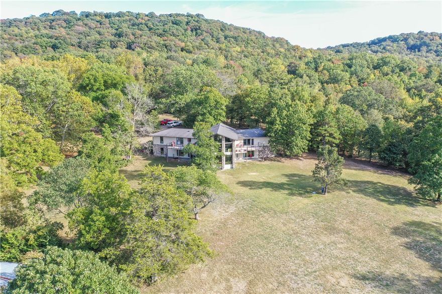 Beautiful Contemporary home with a lake view & park like setting. Walk in the front door and you will see the 4x8 Koi pond, custom built-ins, vaulted ceilings with floor to ceiling windows to take in the view. Kitchen boasts of SS back splash, ball bearing drawers, butcher block island, SS Kitchen Aide appliances including a 3 temperature beverage frig, double oven, 5 burner countertop range, microwave and refrigerator. Primary Suite has 2 walk in closets and access to a deck, primary bath has double vanities, soaking tub, large walk in shower with multiple shower heads, and a toto toilet. Home has 3 skylights, and 1 solar tube for even more natural light. Each room in the house was custom designed with high end finishes. Work shop in basement, separate breaker panel for a generator. Home has 400 AMP service. 1500 sq ft workshop. All this is on 5.8 acres.