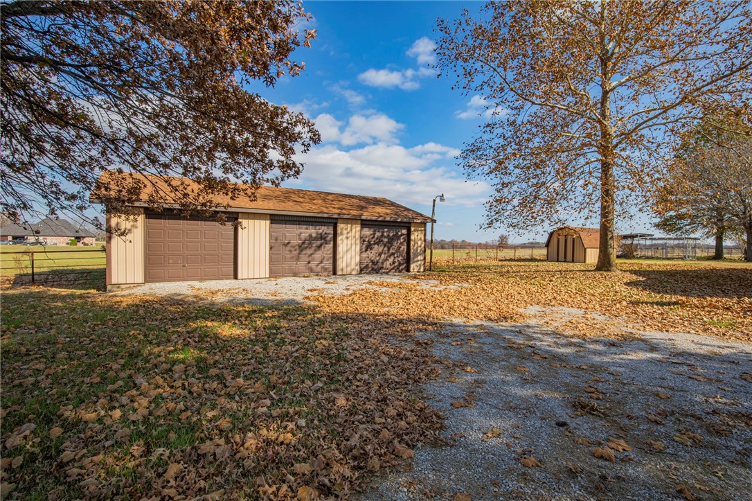 Awesome home in Pea Ridge on large lot with country setting. 3 bedroom, 2 bath home has wood flooring throughout. Built ins, lots of storage, fresh paint. Wood burning fire place in the living room, large family/game room, inground pool, separate 3 bay shop, storage building, dog run. Owner will maintain the pool.