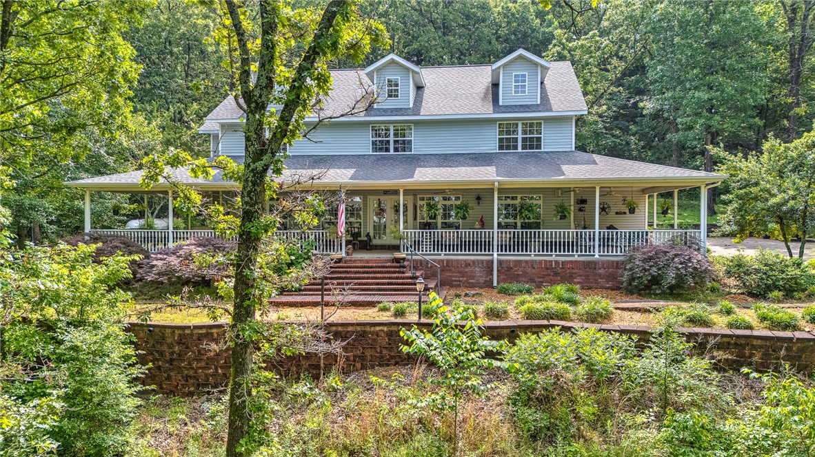 Discover this charming country farmhouse style home nestled on five wooded acres in the desirable Prairie Grove area. This spacious 3-bedroom, 3-bathroom home offers approximately 3,700 square feet of living space, complemented by a beautiful, recently remodeled kitchen (2021) featuring double ovens, a built-in freestanding ice maker, and a refrigerator that conveys.
The home boasts real wood flooring throughout and two primary bedrooms, ideal for flexibility and privacy. Enjoy the privacy and tranquility of your surroundings while relaxing on the expansive 1,500-square-foot covered wrap-around porchāperfect for outdoor entertaining.
Additional amenities include a heated and cooled 864-square-foot metal building (not included in the total square footage), perfect for a workshop or storage, and a long driveway lined with 25 exterior lamp posts that enhance the property's charm and security. The property offers the perfect combination of modern comforts and rustic appeal in a serene, wooded setting.