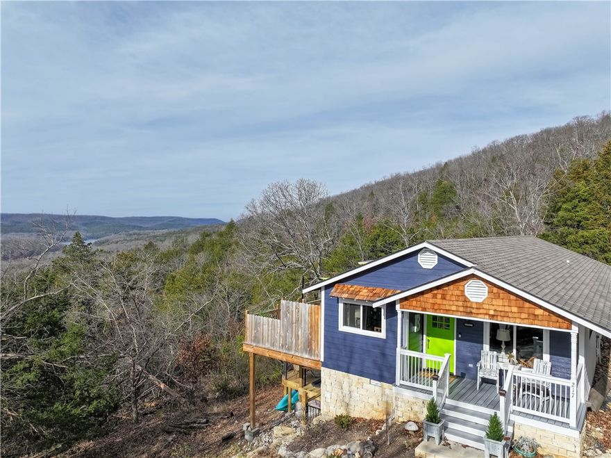 BREATHTAKING VIEWS of the lake and mountains year round!  This Holiday Island home sits on an unusually large lot that feels spacious and remote, while still being close to shopping, golf and neighborhood amenities.  This beautifully remodeled cottage features lush finishes:  new windows and doors, granite countertops, new flooring and live-edge wood shelving, all new stainless steel appliances and water heater.  A new gas fireplace makes winter days feel cozy.  The gorgeous brand-new wooden upper-and-lower decks feature stunning views year-round, with an adorable cowboy/cocktail pool on the lower level.  Just across the street from walking trails, and minutes from the Holiday Island Campground in one direction and the Holiday Island Marina in another.  This would make a lovely residence OR a fabulous getaway cottage.  Ideal for nightly rental.  Call to see it today!