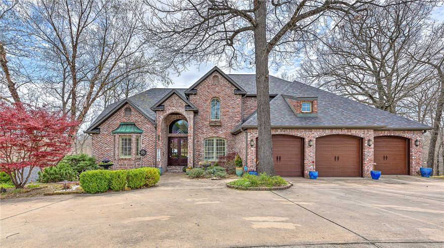 Exquisite home with intricate detailing throughout all 3 levels.  Situated on 2 premium lots (.62 acres), this home is truly made for both entertaining and everyday living with plenty of space inside and out to enjoy fabulous, private views from stunning windows or from 2 spacious decks. Enjoy the open floor plan, 25' ceilings and the chef’s kitchen with energy efficient appliances, plenty of cabinets and a lovely sitting area in front of the 2 sided fireplace.  Walk up the beautiful wood staircase to 2 bedrooms adjoined by a jack and jill bathroom, 1 bedroom with an ensuite, a bonus room and study nook.  The basement, with 12' ceilings, comes complete with a theater room, expansive living space, large bedroom and bathroom, plenty of storage, a storm shelter as well as a full kitchen for entertaining.  Adjoining the house is a 20x40 all brick outbuilding with a separate driveway that can serve as a 4 car garage or workshop.