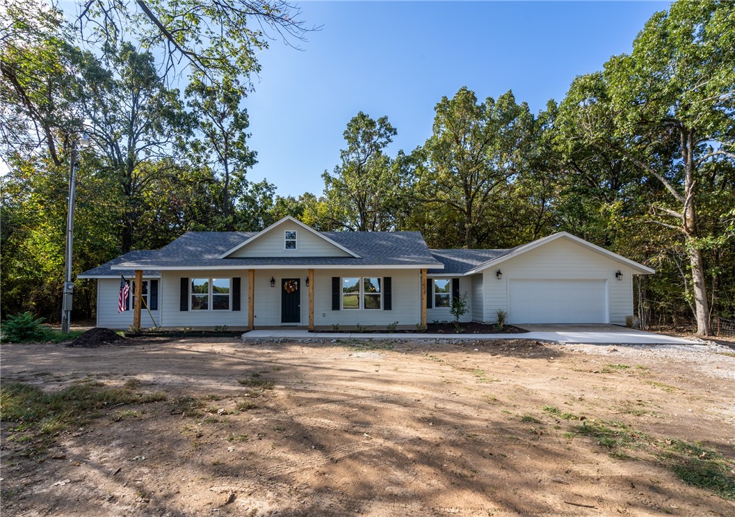 Location! Location! Location! This home just can't be beat! Spend time around the fireplace in the open living area curled up reading a book or watching tv. The well laid out kitchen is a dream with a great island for baking. During the cool fall mornings sit on your covered front porch enjoying views of your spacious yard and all the wildlife! This 4 bedroom 2 1/2 bathroom home is beautifully renovated, move in ready and includes a spacious primary bedroom with a walk in closet, primary bath with walk in shower and double sinks. The laundry room includes the half bath and provides plenty of space to stay organized. The fourth bedroom could also function as work from home/office space and the attached garage keeps you dry when you come in and out on a rainy day. Add in the oversized lot, rural feel and the friendly deer that frequent the yard and you get the best of country living right in town. Walk to the school to cheer on the Wolves under the Friday Night Lights! Small town living at it's best!