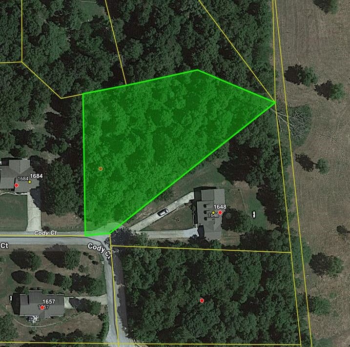 Wooded lot on paved road with water & electric available. Great building site in established neighborhood. No mobile homes allowed.