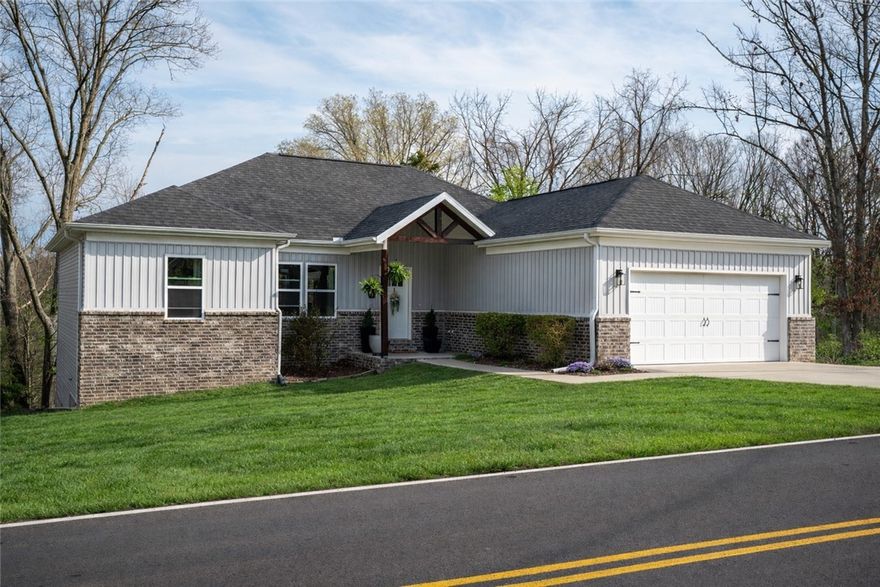 Wake up surrounded by trees and hop on the trail from your backyard, with Blowing Springs just minutes away. Outdoor lovers will appreciate seeing the Back 40 bike trail and the Greenway just beyond the property, with golf, pickleball, tennis, and a community pool all nearby. Step onto the spacious covered deck and enjoy the privacy of a wooded backyard that feels like your own retreat. The home also offers extra gravel parking, perfect for an RV, boat, or camper. Inside, the open split floor plan is designed for both comfort and entertaining. You will find granite countertops, a large island, custom cabinetry, engineered hardwood flooring, and shiplap accents that add warmth and character throughout. Brand new flooring has recently been installed so that there is no carpet anywhere. Pull up to excellent curb appeal and a welcoming front porch that sets the tone for the care this home has received. Immaculately maintained and exceptionally clean, this Bella Vista home truly feels like new. Come see it ASAP!