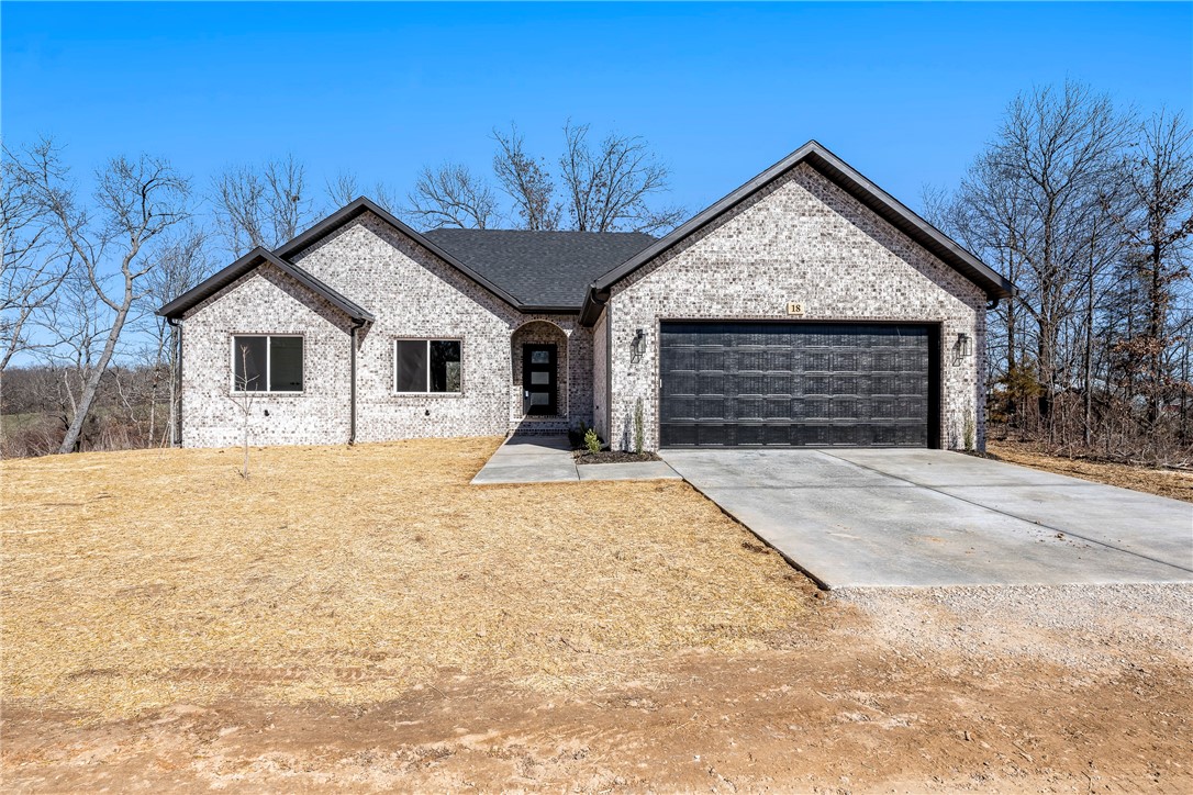Another beautiful home by Elite Thomas Homes. Located on the far east side of Bella Vista off Looney Rd. Pea Ridge schools. One of the few flat lots in Bella Vista. This popular 3 bedroom, 2 bath floorplan also has an oversized 2 car garage. Vaulted ceilings and beams in the main area. Open concept with vent free gas fireplace and stack stone. Spacious kitchen with large kitchen island. Sedona brush finish countertops, white brick subway tile backsplash, and stainless steel appliances. Large primary bedroom with walk in closet and master bathroom with dual vanity, large tile shower with dual shower heads and separate toilet area. Other side features second and third bedroom and guest bathroom. Access the large covered patio from the kitchen. Great backyard with wood privacy fence.