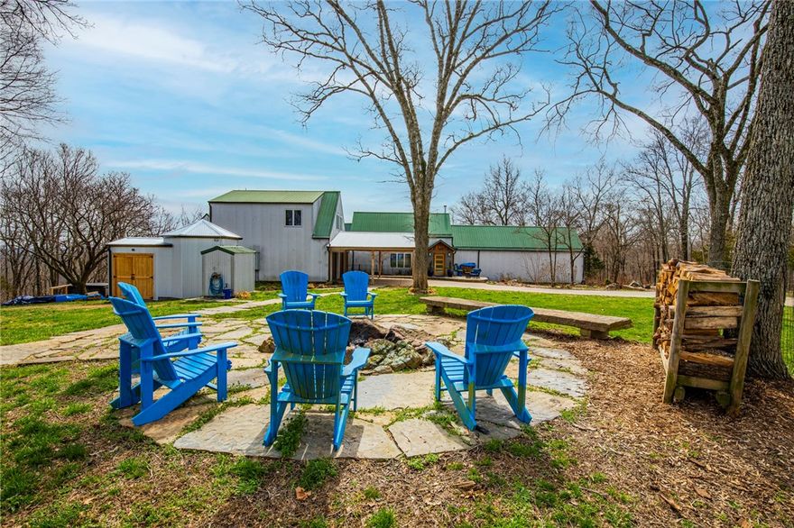 427 Beautiful acres offers a special kind of privacy while only being 25 minutes from Rogers and 9 minutes to Beaver Lake. The 4477 Sq. Ft. home sits 1/2 mile down a concrete driveway and was built in 1996 but has been completely remodeled with high-end upgrades to include: Granite countertops, custom walnut cabinets, hardwood floors, high efficiency wood burning fireplace, heated floor in master bath with steam shower, double oven, thermador appliances, tornado shelter/safe room, propane powered generator, hot tub, and much more. The custom home has 4 bedrooms, 4 bathrooms, 1 half bath, 1 office. The main house has an attached 2 car garage and another detached 2 car garage/workshop sits just to the north a short distance. Above the detached garage is an additional 736 Sq. Ft. living quarters that is fully functional with a kitchenette and full bath. The property includes: Professional landscaping with rock work, 12'x20' green house, garden area, 12'x12' dog house, fire pit, hot tub and propane generator.