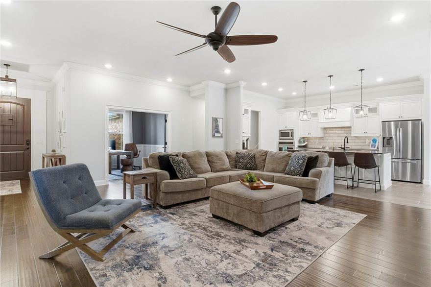 Rarely does a floorplan this well designed come available in Bentonville—especially one backing up to greenspace and just minutes from downtown Bentonville. Welcome to 970 Clark Circle, offering 4 bedrooms on the mail level, 3 full baths, a dedicated office downstairs, and a versatile bonus room designed for a media room or 5th bedroom. The well-appointed kitchen is ideal for both everyday living and entertaining, featuring a gas cooktop and great connection to the main living areas. Step outside to enjoy a private backyard retreat and seamless indoor-outdoor living with a covered porch and retractable screens that transform the space at the touch of a button. Smart home upgrades include Nest thermostats, Nest smoke detectors, WiFi-enabled garage doors, insulated garage doors, and a professionally finished epoxy garage floor. The spacious 3-car garage provides excellent room for vehicles, storage, or hobbies. Neighborhood amenities are just steps away, including a community pool, playground, and basketball court.