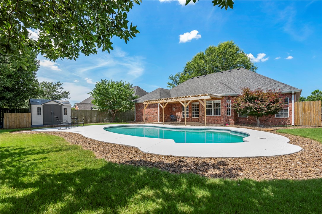 BACKYARD OASIS in highly sought after Ridgecrest Meadows just perfect for your indoor and outdoor living! Come relax out back while you read under the covered pergola, sunbathe, or swim in your in-ground POOL! Fantastic for entertaining & gathering with friends! Amazing all-brick 4 bedroom, 3 full bath home w/ lots of natural light and beautiful curb appeal. Split bedroom plan with private en-suite guest bedroom w/full bath. Stainless steel appliances, granite counters, tall ceilings, and neutral colors throughout. Formal dining area, breakfast nook overlooking the pool, landscaped backyard, mature trees, outdoor storage building, floored attic for extra storage, and BRAND NEW CARPET throughout. Great location close to Razorback Greenway bike trails, Pinnacle/Promenade shopping area & restaurants, Walmart AMP, TopGolf and within walking distance to Bellview Elementary! **AGENT OWNED**