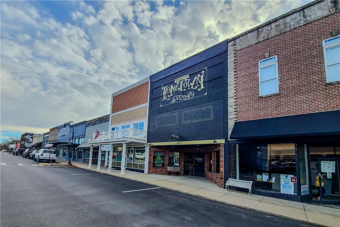 Beautiful historic building in downtown Gravette for sale. 4,000sf +- of open office/retail space with mezzanine, 2 renovated bathrooms (multiple stalls), hardwood floors, bar with granite top, 3 compartment sink, original tin ceilings, retail windows with display wells, mezzanine with a spiral staircase, full walk out basement for storage. Versatile layout for various concepts including office/retail/restaurant, wedding/event venue. Upstairs balcony currently used for entertainment as well has oversized his & hers lounge rooms with updated private bathroom. Courthouse records do not include mezzanine/2nd floor square footage. Seller estimates approximately 4,000sf total.