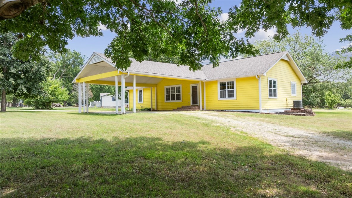 You are going to love your new sunshiney home! From the cheerful exterior to the huge corner lot with beautiful mature shade trees and an enormous shop building, your home is designed for smiles. Your wide-open living area is filled with natural light and gleaming hardwood floors. Even when you're cooking up a storm in your bright, cheerful kitchen with new granite countertops and more storage space than you'll know how to fill, you'll still be in the heart of all the fun. Your split floor plan provides a private space for everyone to get away, while the large back deck offers a sunny spot to enjoy nature and soak up some rays. Then there's your humongous 30x80 shop building! With two 10' bays and driveways leading directly to and from the road, you have more than enough space for your small business, hobbies, absolutely anything you can dream up! Just minutes from downtown Rogers and Monte Ne, you can be anywhere in NWA in no time at all. Be sure to schedule a personal tour of your fabulous new home today.
