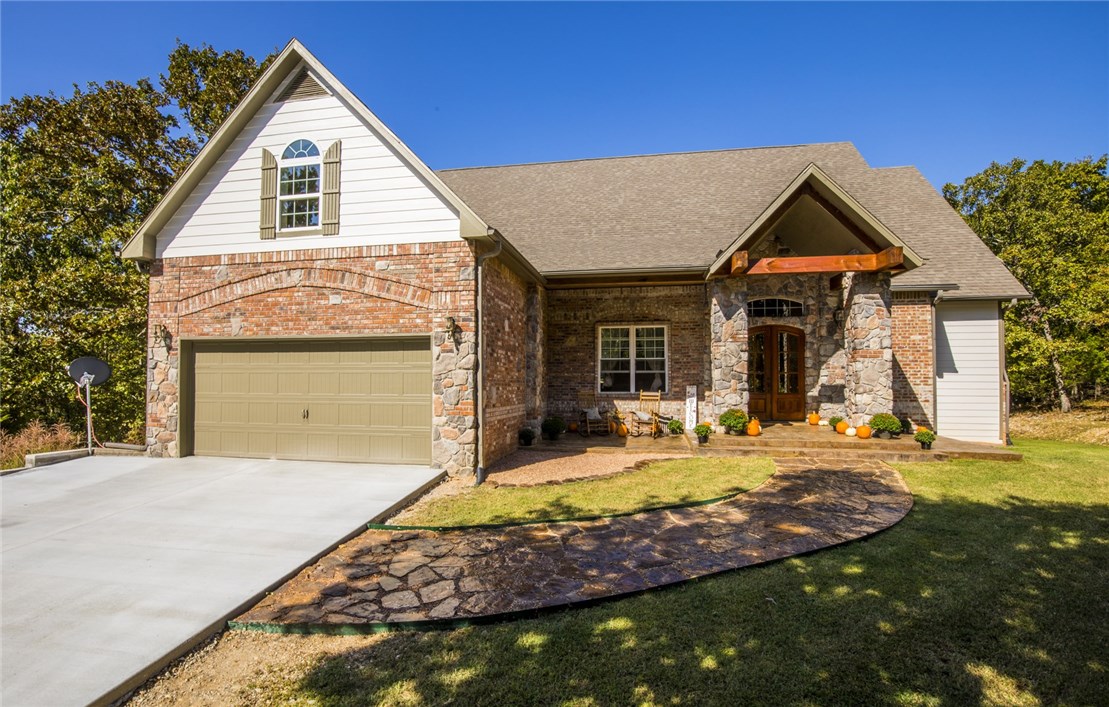 Ever go on vacation and think "Id love to live here"? This home has a "Lodge" feel and was built to entertain. Nestled on 5 wooded acres this home has warmth and an abundance of natural light. The show piece is the large living/gathering area with a custom built 10' table that conveys. Imagine hosting Thanksgiving dinner here. While the main floor is perfect for gatherings and parties the lower level features a second living area/game room, 3 bedrooms, full bath, 2nd laundry room and a craft/bonus room with a sink, counters and cabinets. The upper level features a Master Bedroom, Master Bath and the largest closet I've ever seen. From the catwalk you can watch your family and friends enjoying each others company. Located just 10 minutes from downtown Rogers and only 13 miles from downtown Bentonville makes this a great escape. Come feel the warm and imagine the possibilities with owning this home.