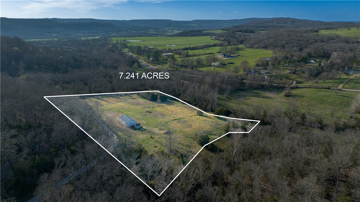 Like-new modern shop house tucked away in the woods on 7.2 acres. Built in 2020 with tile floors in kitchen and bath. Walk-in marble shower. So many options - live-in forever or convert back to a shop. Open living area framed for 3 rooms. 2 mini-split HVAC units and 40-gallon water heater. Welder input plug and wired for electric doors. Cleared site bordered by trees. Storage building with loft. Rural water and Ozarks Go.