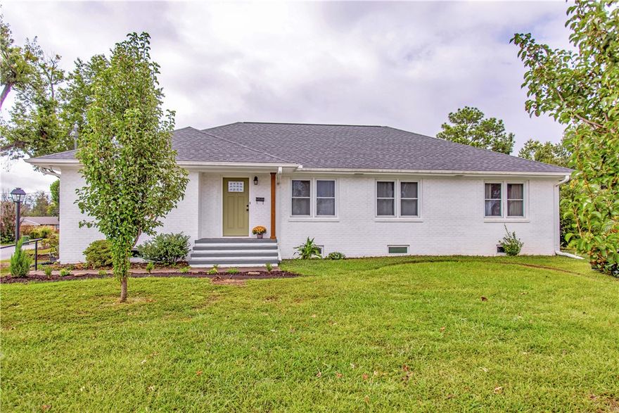 Perfectly situated on a corner lot in the heart of downtown Rogers, this charming home exudes timeless character complemented with bright, thoughtful updates. Beautifully maintained hardwood floors, new light fixtures, updated kitchen cabinetry, and a refreshed bathroom are among the details that add a modern, boho chic touch. A spacious and fully finished basement offers abundant storage options and a versatile living space, complete with an attached workshop area. Built-ins throughout the home enhance functionality and charm, while French drains in the exterior yard provide peace of mind. Outdoors, a large fenced backyard features a lovely garden and greenhouse, ideal for hobbyists and plant lovers alike. With its inviting curb appeal and proximity to Lake Atalanta, Railyard Bike Park, and all the conveniences of the vibrant downtown Rogers area, this home presents a rare opportunity to enjoy both lifestyle and location.