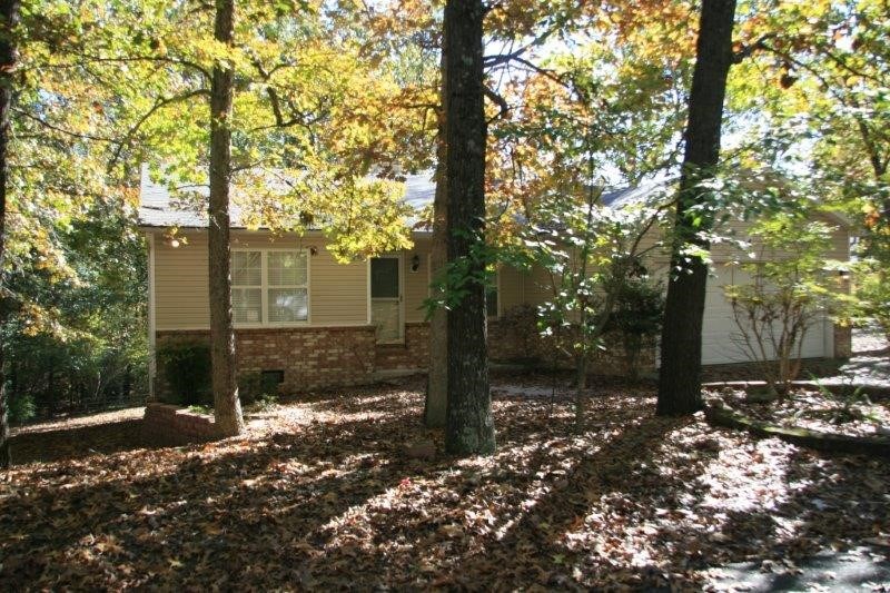 You will “Love” this location! Wooded lot that backs up to “Back 40” Trail, easy access to highway, medical and shopping. Three-bedroom split plan, master has walk-in closet. Open living concept, sunroom with tinted/reflective glass, living room with gas log fireplace (no propane tank provided). Kitchen with island/bar seating for two, GE stainless steel appliances, dishwasher, microwave, electric range/oven and refrigerator. Separate dining area open to sunroom with access to deck. Laundry room with storage, washer and dryer stay. Vinyl, tilt windows for easy cleaning. Roof, 2018. Located on a quiet cul-de-sac street. See today! Smart Investment!