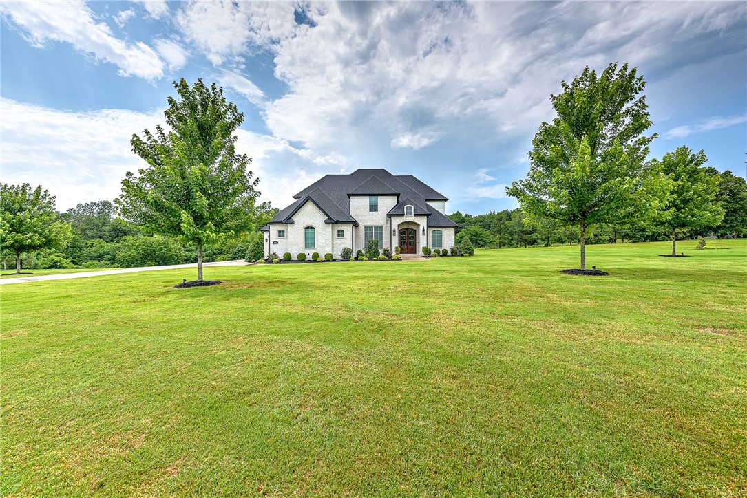 Escape from the Busy lifestyle to this beautiful home on 2+ acres! This custom home features an open living area with a fantastic kitchen "must see!"!!!! 18x18 Sunroom with its own gas fireplace! You will also find a formal dining, main bedroom suite, office and laundry on the main level. Upstairs is 3 more bedrooms, 2 baths another laundry with a vented doggie door!!, and a wonderful entertainment area. 3 car garage that has 1 separate so it can double as a workshop! Neighborhood features a huge pool, tennis court and clubhouse!