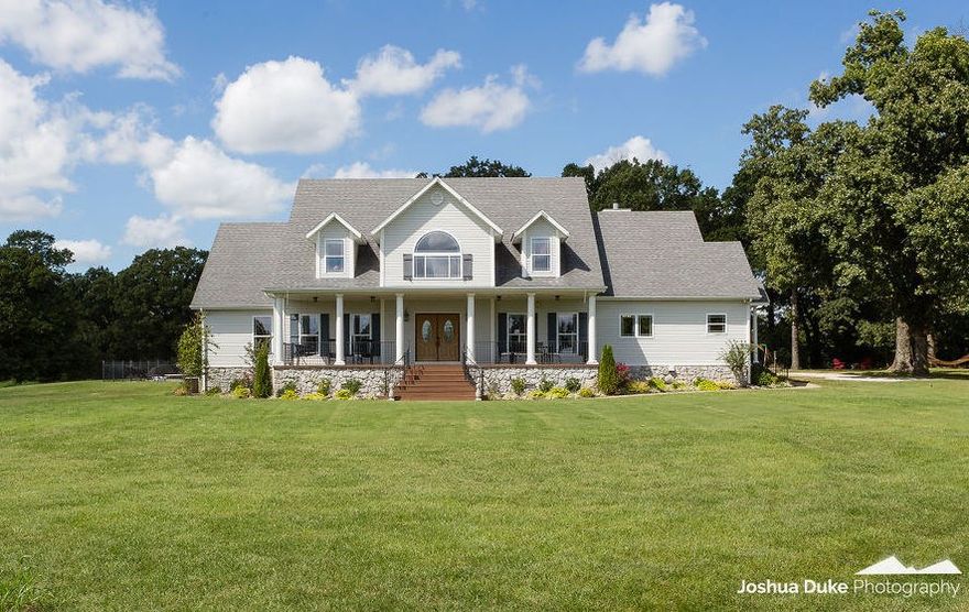 A cup of coffee or glass of wine sipped from the front porch is the perfect way to admire this beautiful 60 acres in Elm Springs, where you'll often see deer but no sign of civilization with a full half mile drive between you and the road. Best of both worlds: a country estate feel with a 10 minute drive to I-49. This home is perfect for horses! It sports a 3000 square foot barn with 3 horse stalls, tack room, workshop and 10 acres fenced horse run. Miles of attic storage! 4 bedrooms plus office, bonus room, a music / art room, and hidden room behind the children's bookshelf! Beautiful saltwater pool area surrounded by pennsylvania bluestone and 820 sqft of cedar decking with 4 person hot tub, all updated in 2014. New sprinkler system and landscaping. Formal dining room for large table. Entire home wired for sound. Upstairs & downstairs sets of washer/dryers. Wet bar with wine fridge. 3 car garage with electric car charging port. Full bathroom off garage for easy access from pool. Solar powered privacy gate.