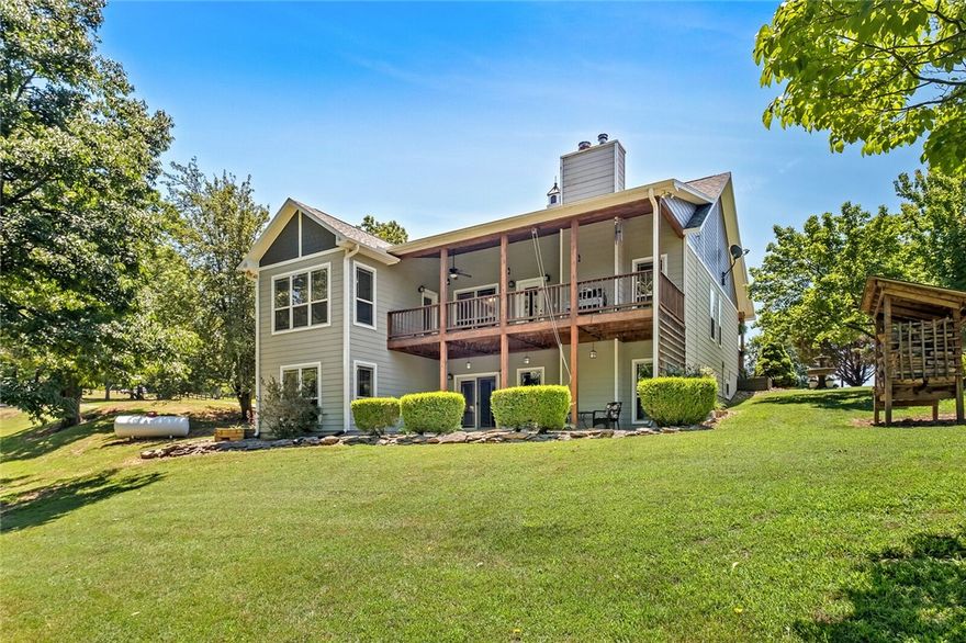 18 acres, a dreamy Ozark oasis with a custom built, steel beam, poured wall foundation craftsman style awaits your visit. Only a mile from Indian Creek Park, Beaver Lake boat ramp and the Bertram, White River boat ramp. Location is a short 10 miles to Roaring River, MO, 22 miles to Downtown Rogers, 9 miles to Eureka Springs.

The main house offers a practical floor plan with 3 bedrooms, 3 baths, 2 fire places. The living room, office space, master bedroom, formal dining, eat in kitchen and laundry room complete the main level.  From the great front porch and several patios on both both levels, one can enjoy lots of out door living areas. The finished walkout basement with kitchenette, bonus living and gym/storage room are also part of this comfortable establishment. 
Be sure to check out the three outbuildings, including 15X23 foot detached party pavilion, seven person hot tub, a separate 30X24 foot barn/shop building and additional 18X30 foot boathouse/barn.