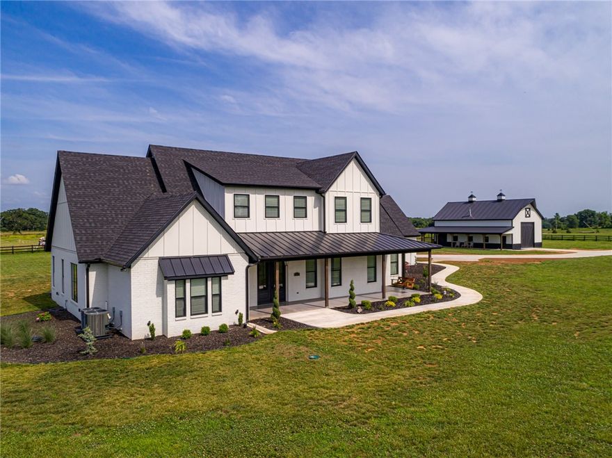 This Breathtaking 4 Bedroom 4.5 bath New Traditional Farmhouse is located in a Bentonville gated community and sits on a fully fenced flat 5.43 acres with a fully stocked community pond and dock.  This exquisite home was completed in November, 2019, and has an open and airy floor plan with an inviting outdoor screened in living space with woodburning fireplace that connects to the living room.  The home has multiple features not found in other homes, such as a safe room, above and below ground tornado shelter that is accessible only from inside the home, security system, security cameras, central vac, solar, generator connection that runs all vital home connections and is 30% more energy efficient with wrapped foam board insulation and has a 30’x50’ Barn with a wood burning stove.
